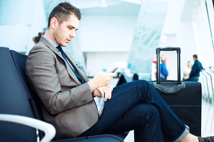 Businessman At Airport With Smartphone And Suitcase smartphone trends